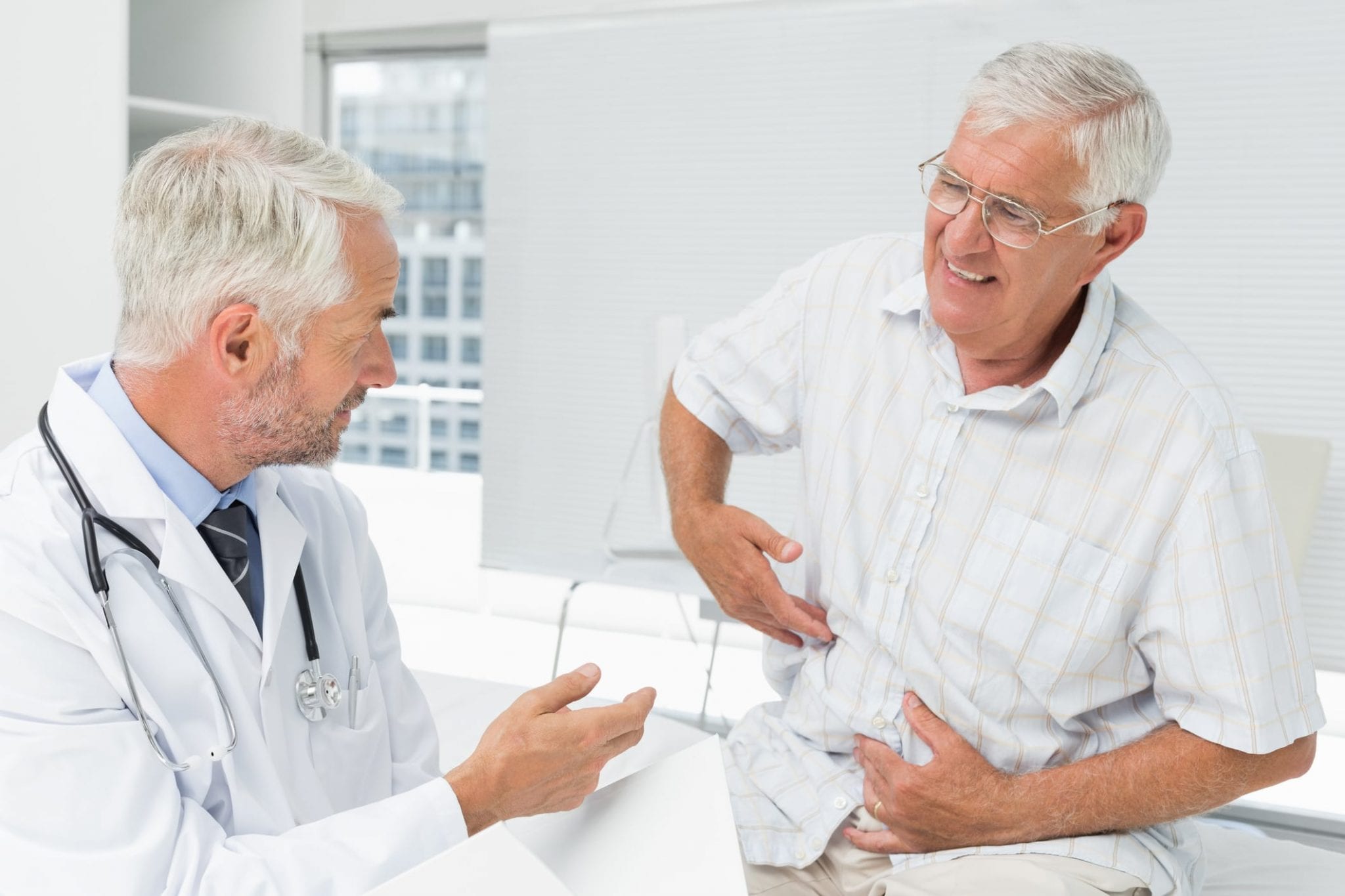 Patient Pointing To Abdomen At Doctor’s Office