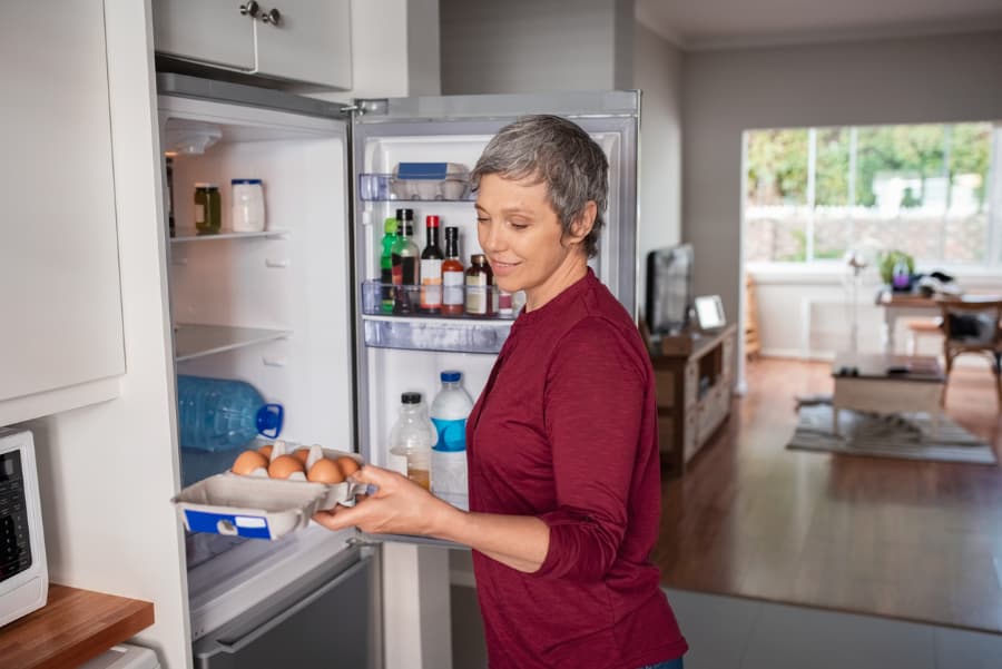 Woman Taking Eggs From Refrigerator
