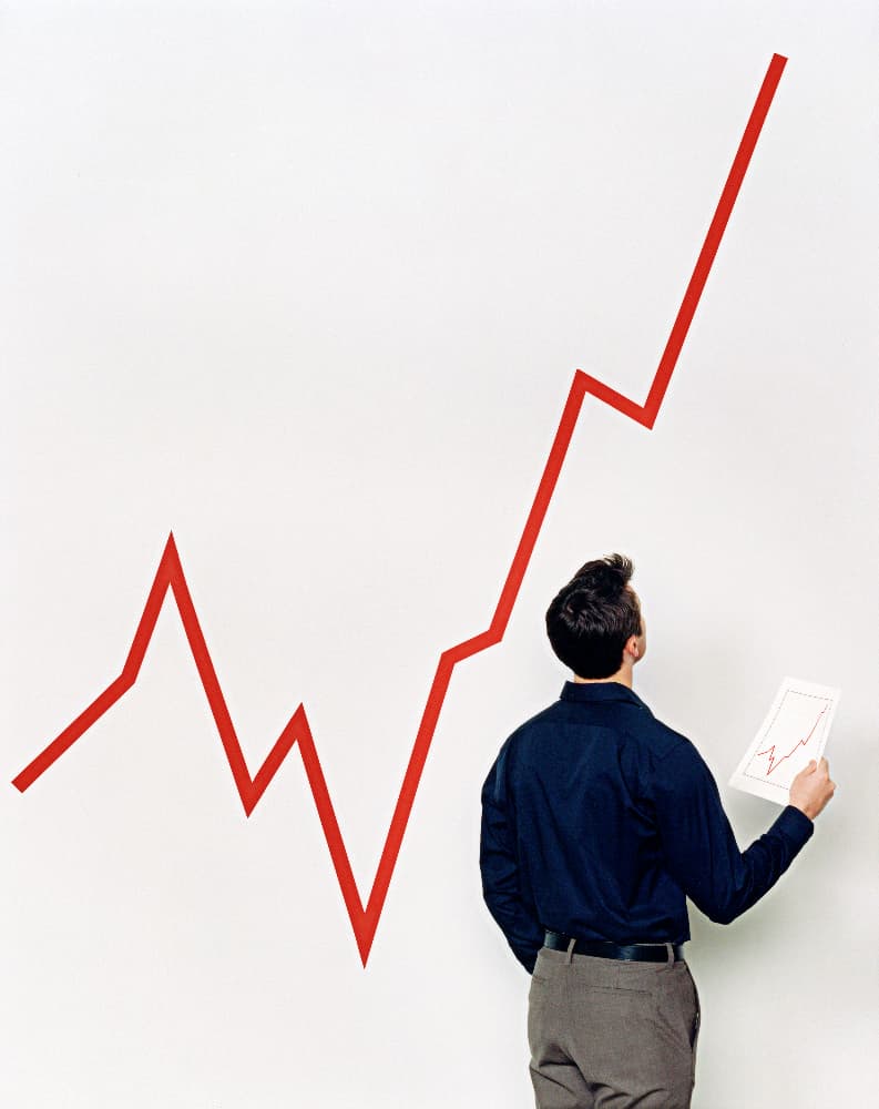 man looking at large line graph